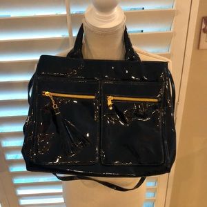 Black patent leather bag. Removable shoulder strap. Zippered pockets Nice tassel